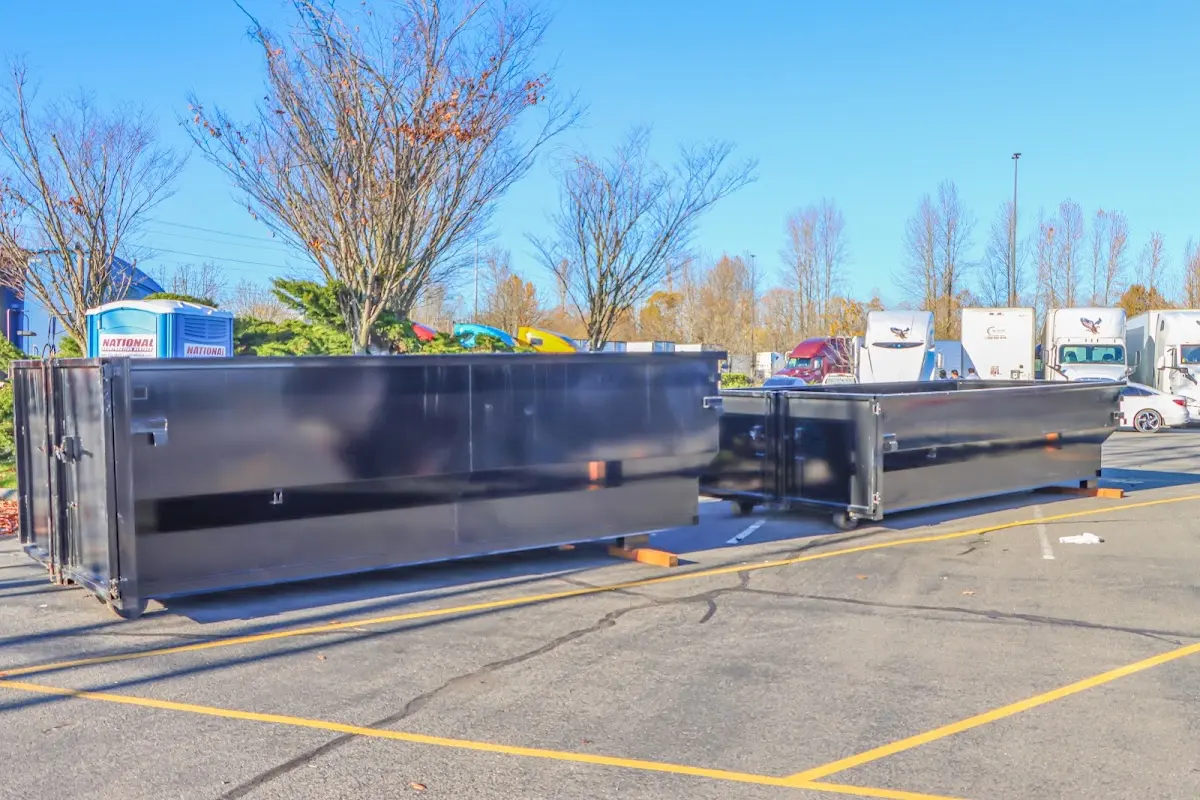 Professional dumpster rental service with roll-off container on residential driveway in Watertown